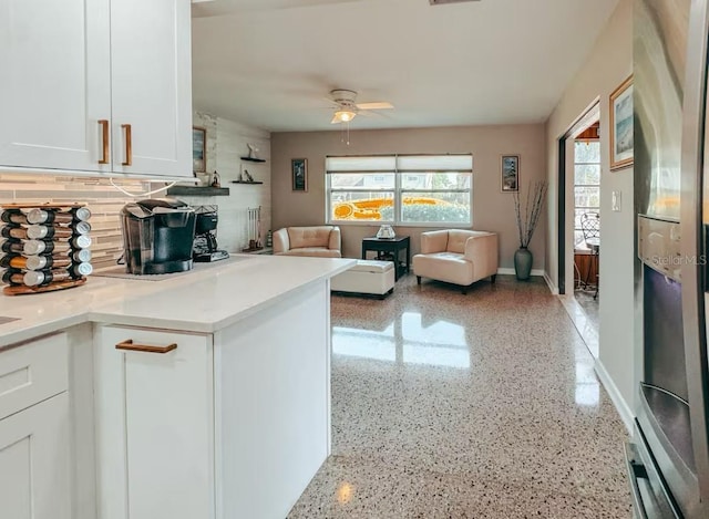 kitchen with tasteful backsplash, ceiling fan, and white cabinets