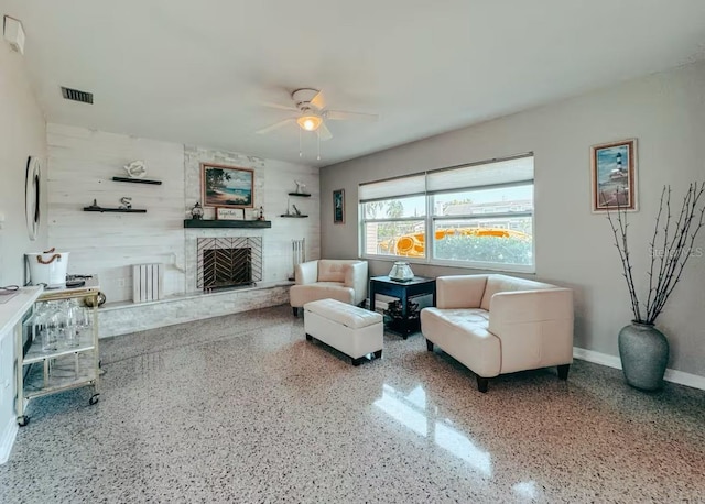 living room featuring a fireplace and ceiling fan