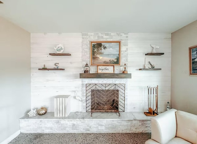 living room featuring a fireplace and wooden walls