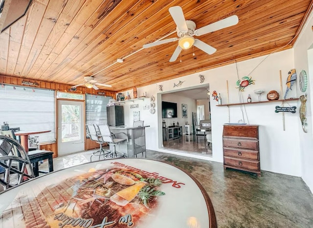 interior space with ceiling fan, wooden ceiling, and concrete floors