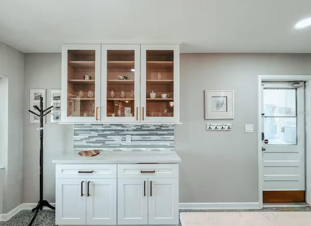 bar featuring white cabinetry and tasteful backsplash