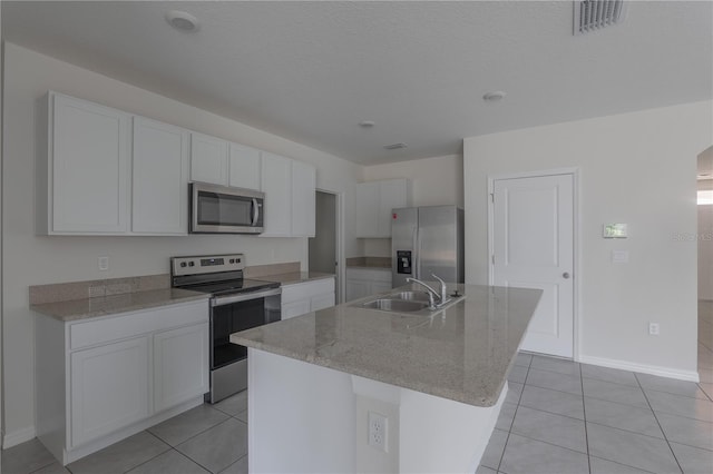 kitchen featuring sink, white cabinets, light tile patterned floors, a center island with sink, and appliances with stainless steel finishes