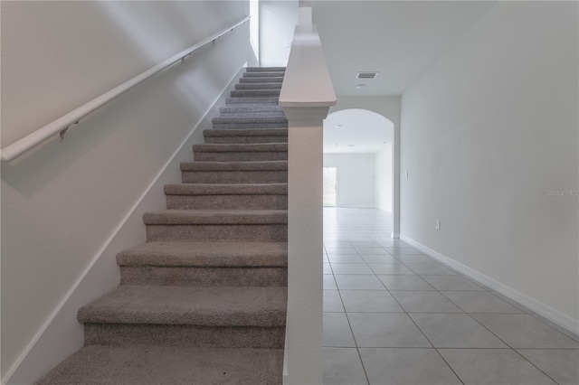 staircase featuring tile patterned flooring