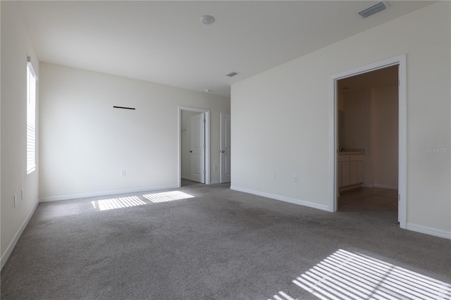 unfurnished room with carpet flooring and a healthy amount of sunlight