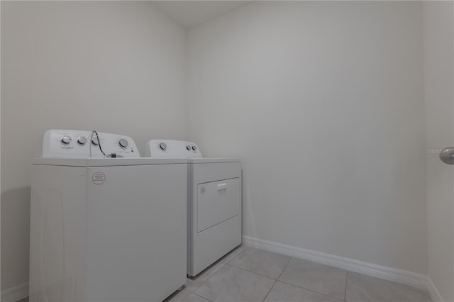 clothes washing area featuring washer and dryer and light tile patterned floors