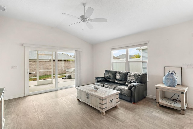 living room featuring ceiling fan, vaulted ceiling, and light hardwood / wood-style flooring