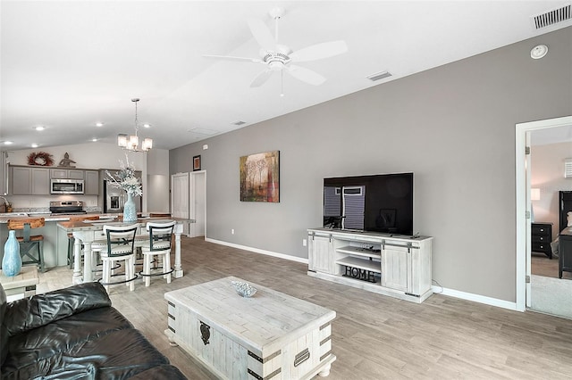 living room featuring ceiling fan with notable chandelier, light hardwood / wood-style flooring, lofted ceiling, and sink