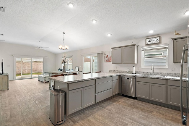 kitchen with hardwood / wood-style floors, sink, vaulted ceiling, stainless steel dishwasher, and kitchen peninsula