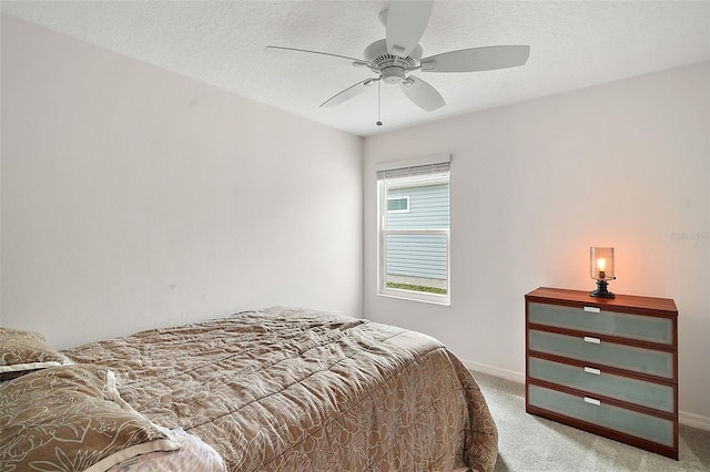 bedroom featuring a textured ceiling, carpet floors, and ceiling fan