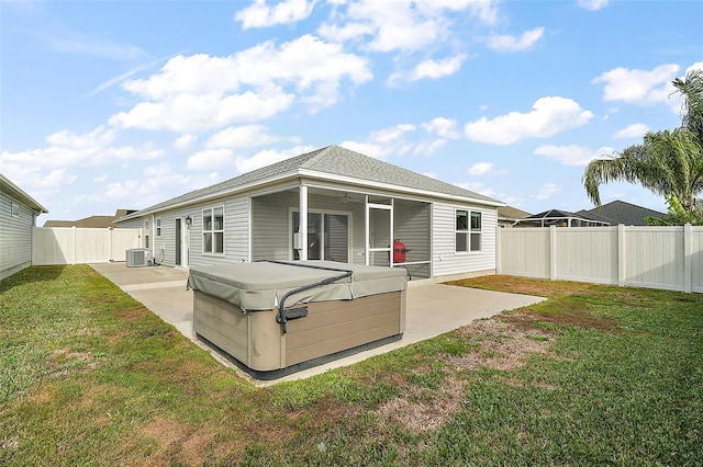 back of property featuring a patio, a hot tub, cooling unit, and a lawn