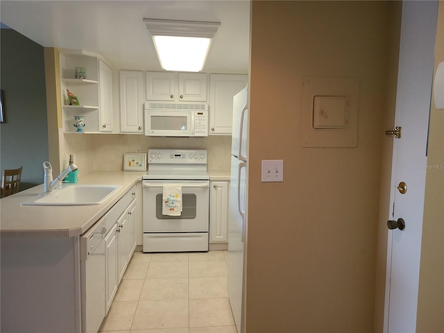 kitchen featuring white appliances, white cabinets, sink, light tile patterned floors, and kitchen peninsula