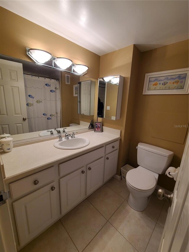 bathroom featuring tile patterned flooring, vanity, and toilet