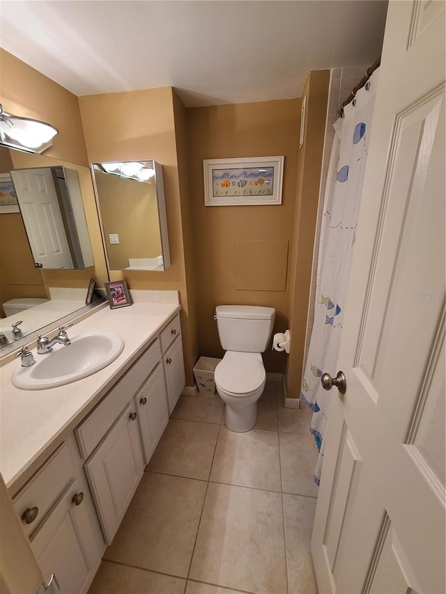 bathroom featuring tile patterned flooring, vanity, and toilet