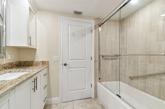 bathroom with vanity and combined bath / shower with glass door