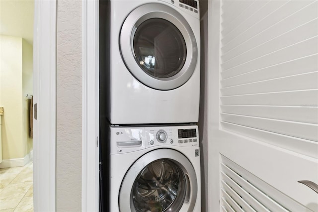 washroom with tile patterned floors and stacked washing maching and dryer