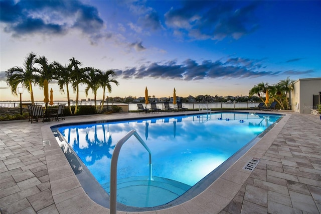 pool at dusk with a patio