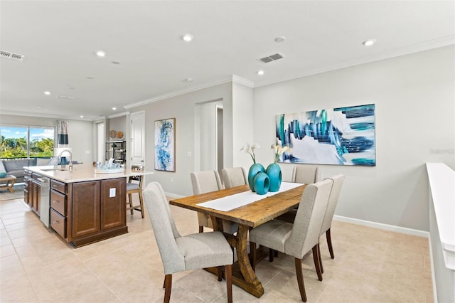 dining room featuring light tile patterned floors, crown molding, and sink