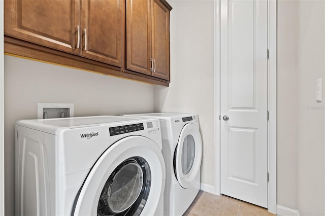 laundry room with cabinets, separate washer and dryer, and light tile patterned flooring