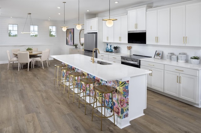 17390 Moonflower Dr Unit 202, Venice, FL 34293 - kitchen with a center island with sink, light countertops, a kitchen bar, appliances with stainless steel finishes, and a sink