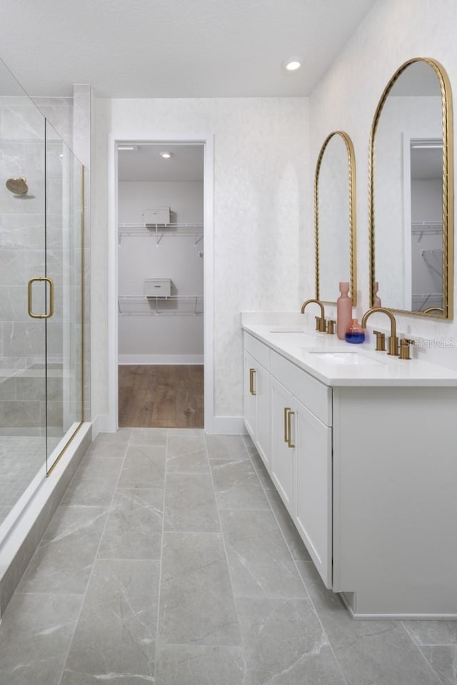 17390 Moonflower Dr Unit 202, Venice, FL 34293 - full bathroom with a walk in closet, a shower stall, double vanity, and a sink