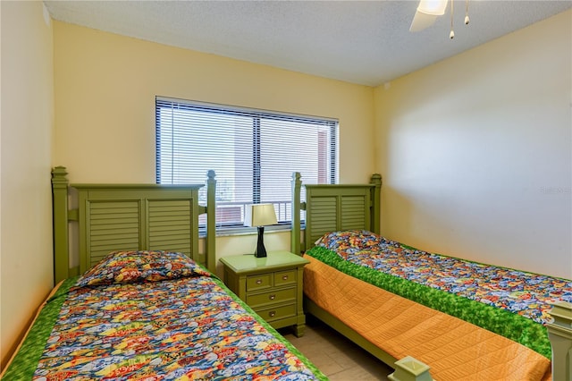 bedroom with ceiling fan and a textured ceiling