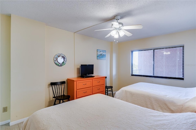 bedroom with ceiling fan and a textured ceiling