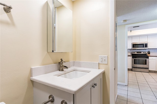 bathroom featuring a textured ceiling, vanity, tasteful backsplash, and tile patterned floors