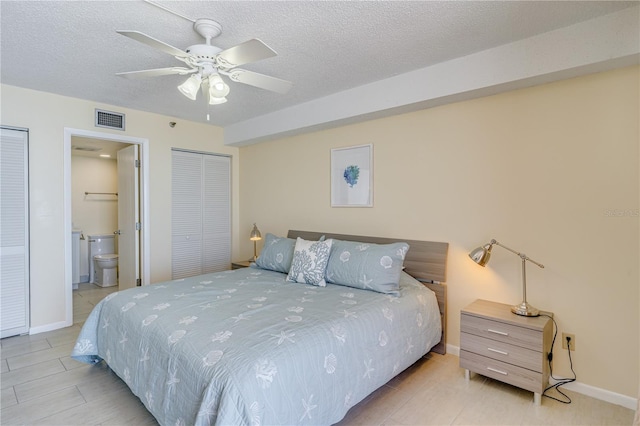 bedroom with ceiling fan, light tile patterned floors, ensuite bathroom, and a textured ceiling