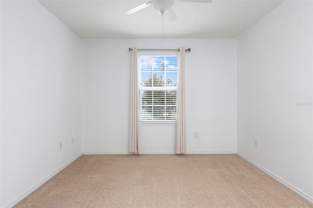 spare room with ceiling fan and light carpet