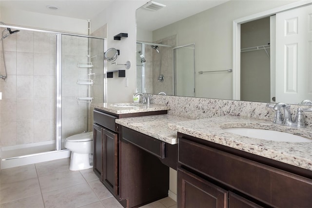 bathroom with an enclosed shower, vanity, tile patterned flooring, and toilet