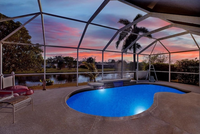 pool at dusk featuring a water view, glass enclosure, and a patio area