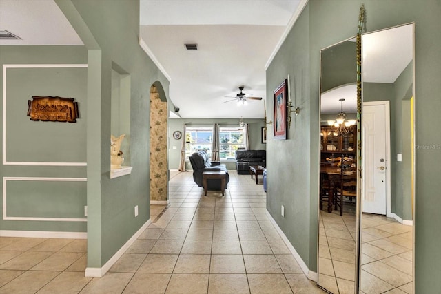 hallway featuring light tile patterned floors and an inviting chandelier