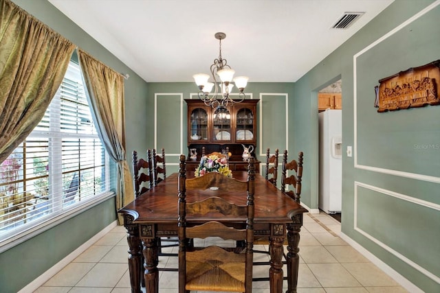 dining room featuring plenty of natural light, light tile patterned flooring, and an inviting chandelier