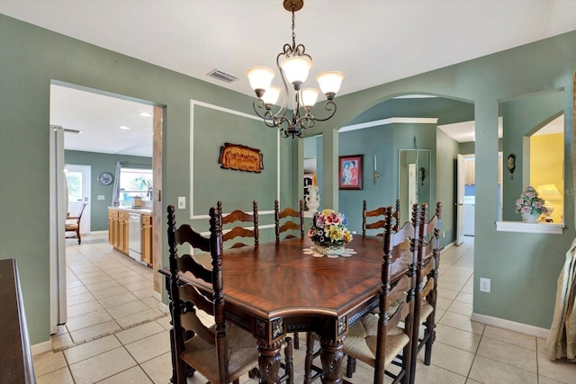 dining area with light tile patterned flooring and a chandelier