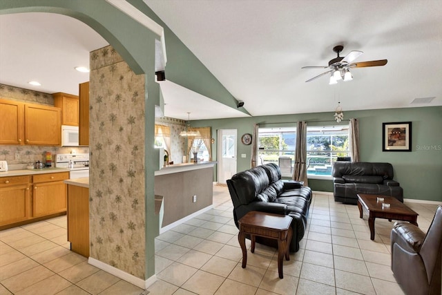 tiled living room featuring ceiling fan and vaulted ceiling