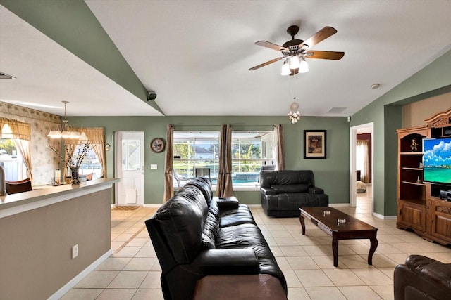 living room with ceiling fan with notable chandelier, vaulted ceiling, and light tile patterned flooring