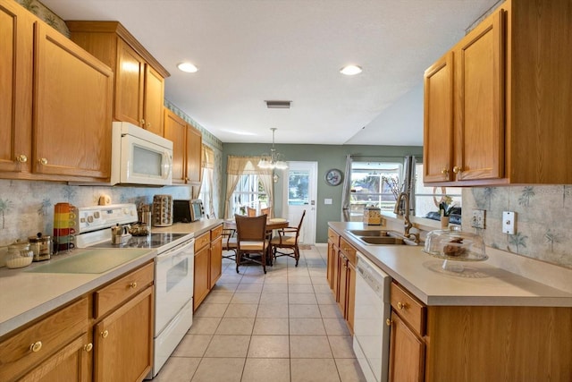 kitchen with white appliances, sink, pendant lighting, an inviting chandelier, and light tile patterned flooring