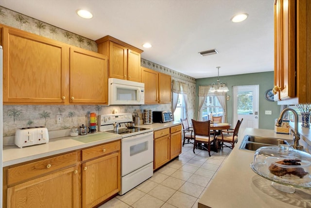 kitchen featuring pendant lighting, white appliances, an inviting chandelier, sink, and light tile patterned floors