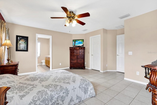 bedroom featuring ceiling fan, light tile patterned floors, and ensuite bath