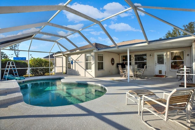 view of pool featuring glass enclosure and a patio area