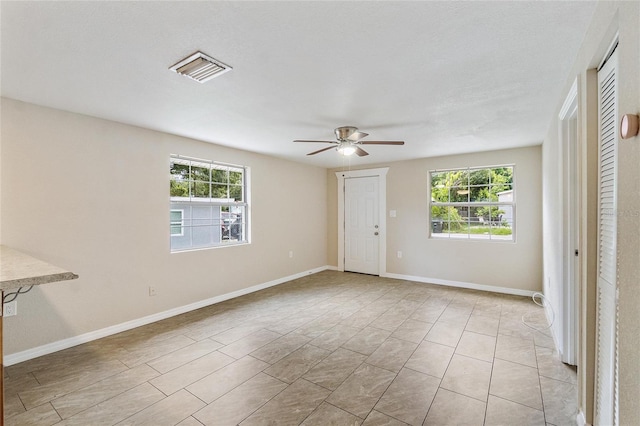 empty room with plenty of natural light and ceiling fan