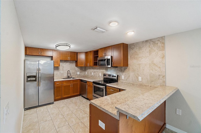 kitchen featuring kitchen peninsula, sink, appliances with stainless steel finishes, and tasteful backsplash