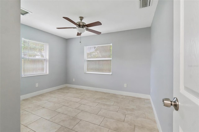 tiled spare room featuring ceiling fan and a wealth of natural light