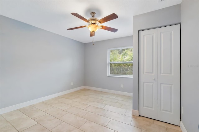 unfurnished bedroom with ceiling fan, a closet, and light tile patterned flooring