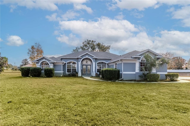 ranch-style home with french doors and a front lawn