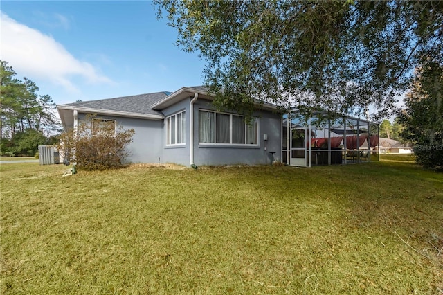 view of side of home featuring a lawn and glass enclosure