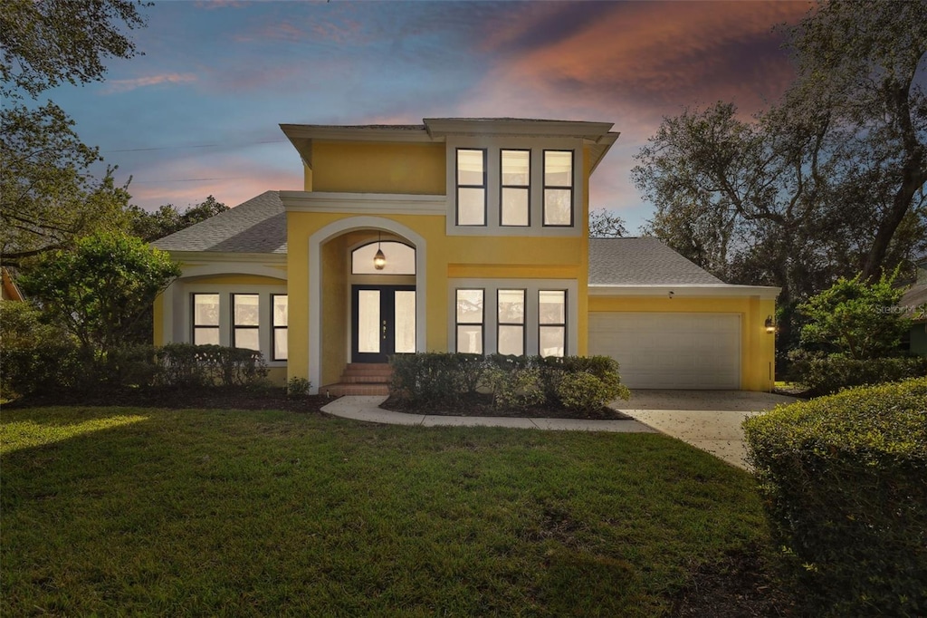 view of front of house featuring a yard, french doors, and a garage