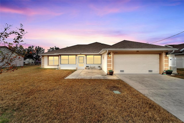 view of front of home featuring a garage and a yard