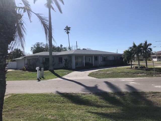 ranch-style house featuring driveway and a front yard