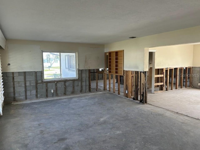 empty room featuring concrete flooring and concrete block wall